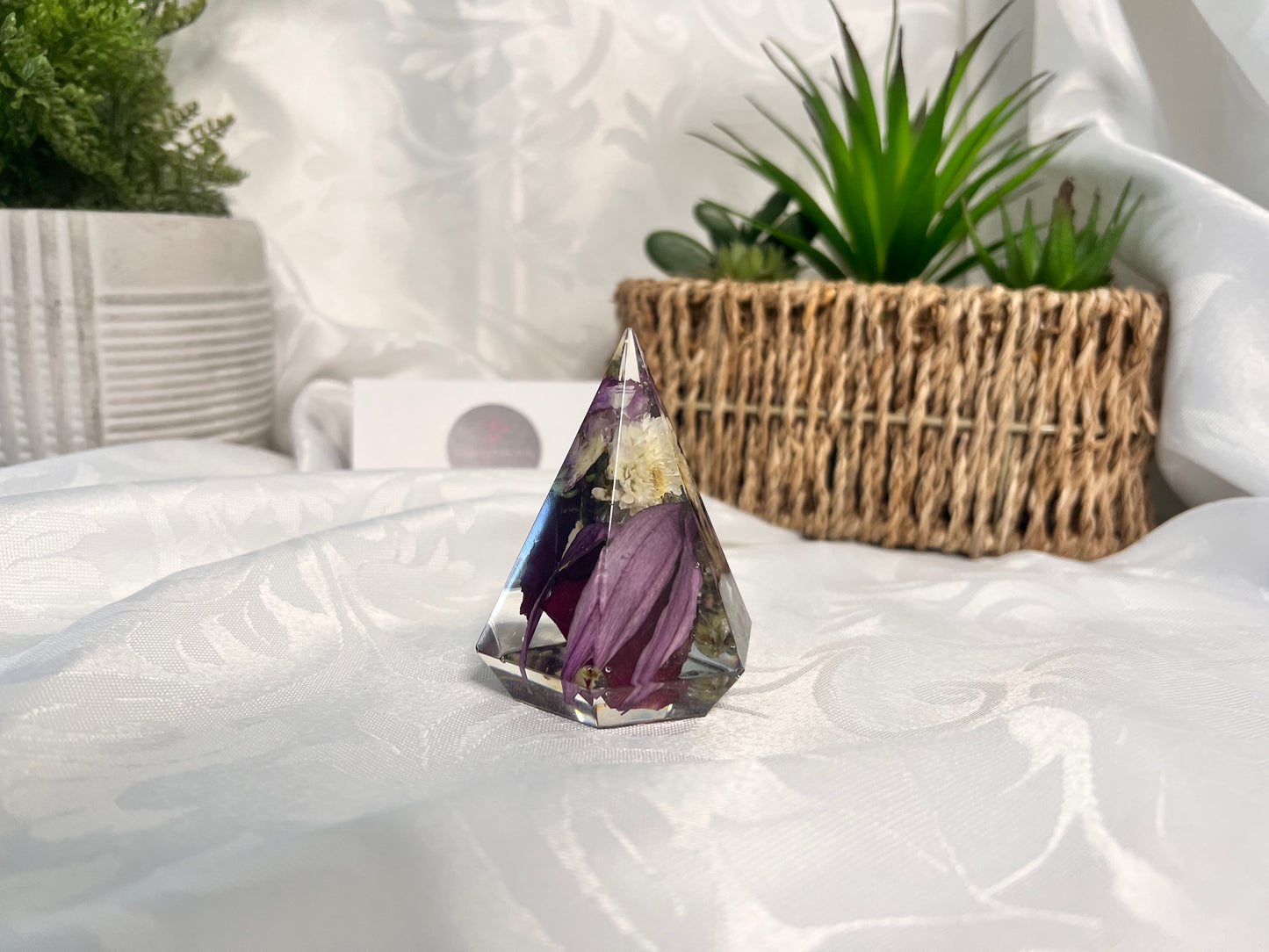 Purple and white dried petals inside a resin ring holder