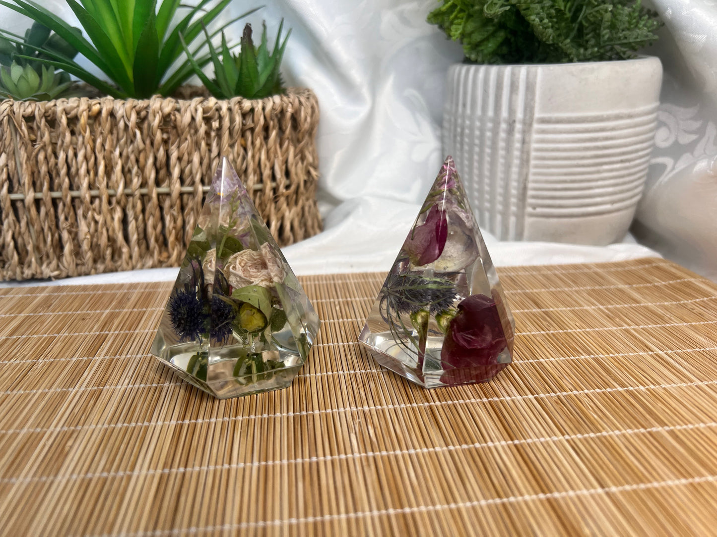Shades of red and pink flowers with thistles inside of two separate ring holders.