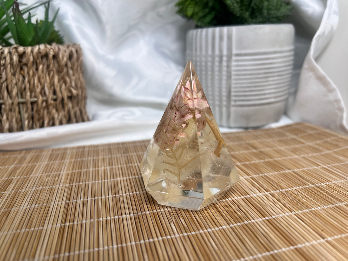 White and pink foliage inside a clear resin ring holder.