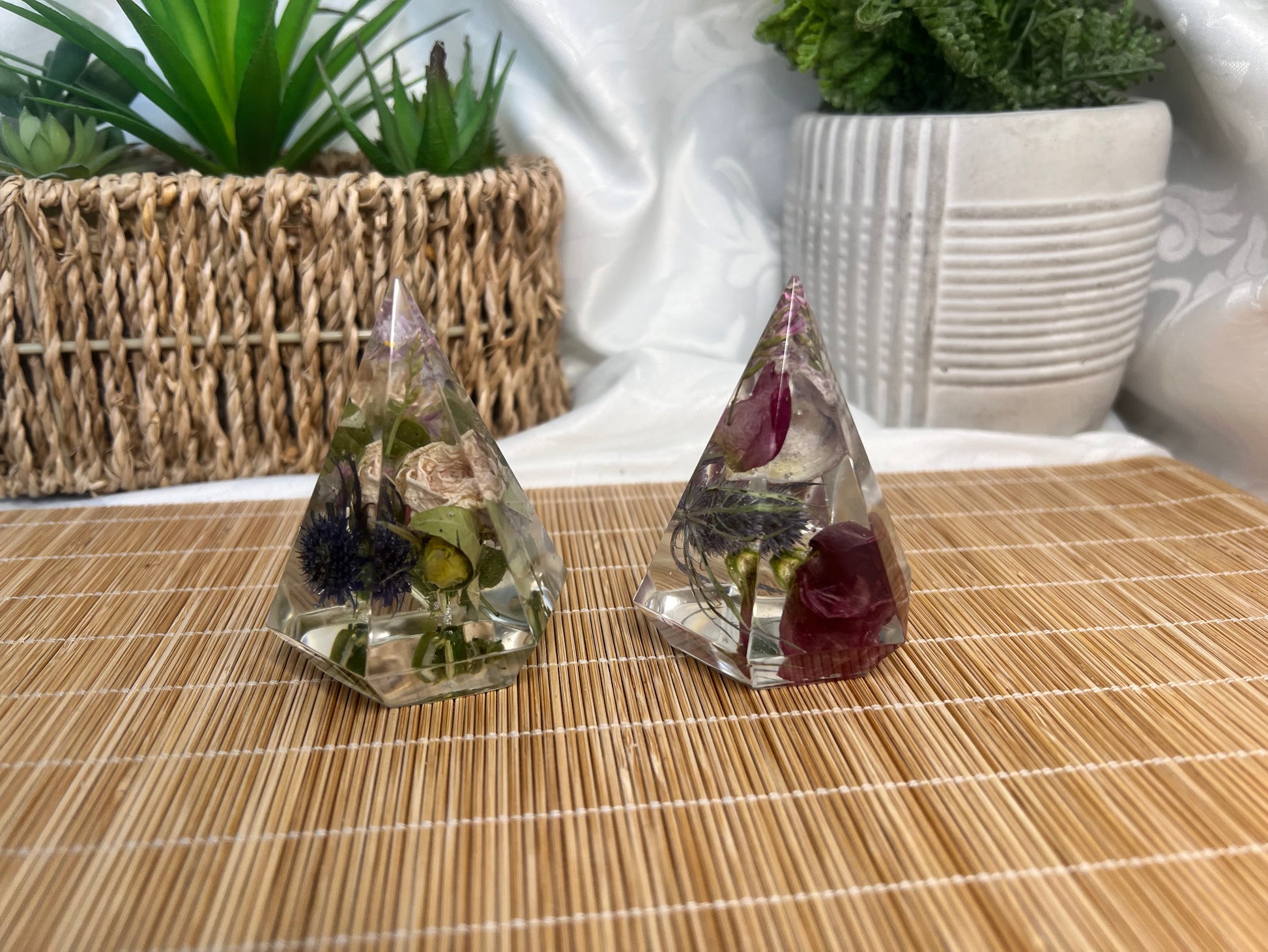 Shades of red and pink flowers with thistles inside of two separate ring holders.